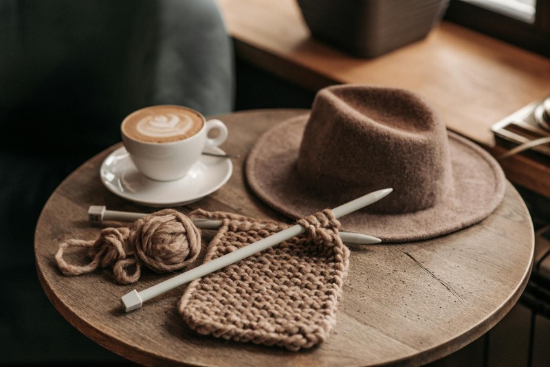 Bord med hat, kaffe og strikketøj
